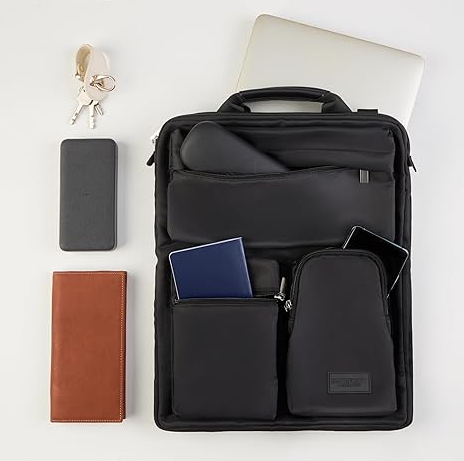 Black over-luggage organizer bag laid flat with passport, phone, wallet and tablet in its front pockets