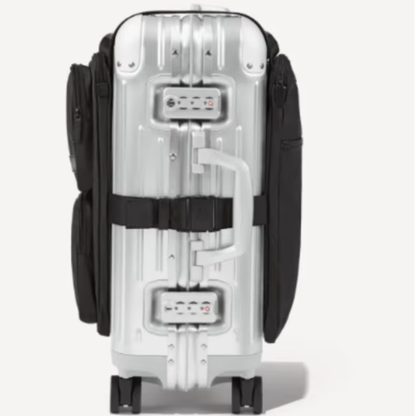 Back of a silver aluminum suitcase showing the adjustable straps that secure the luggage organizer bag